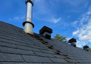 Damaged curled shingles on pitched roof